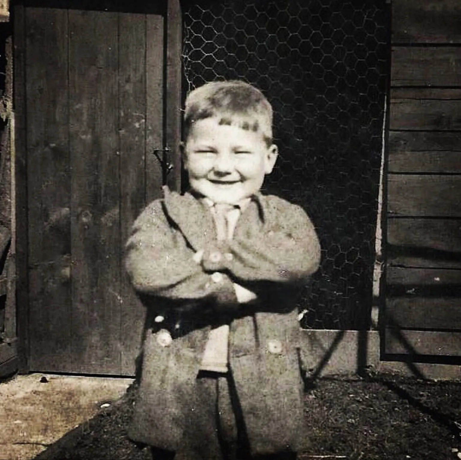 Young Bill Bain as a child, arms crossed with a big smile
